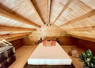 a large room with a bed in a wooden room at Mountain Eco Shelter 3 in Funchal