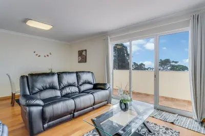 a living room with a leather couch and a glass table at Boeiro I in Caniço