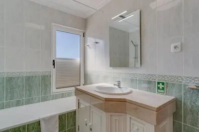 a bathroom with a sink and a mirror at Boeiro I in Caniço