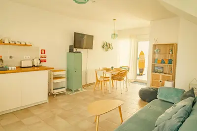 a kitchen and a living room with a couch and a table at Wayra Lodge [Kanchay] in Raposeira