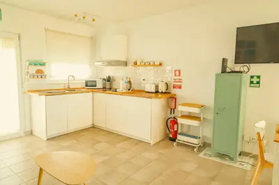 a kitchen with white cabinets and a green refrigerator at Wayra Lodge [Kanchay] in Raposeira