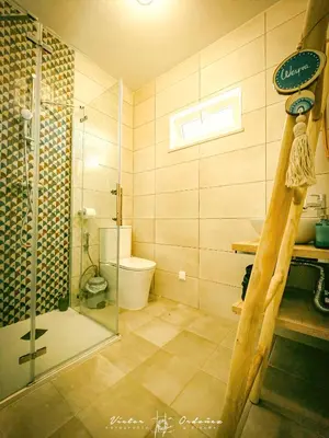 a bathroom with a glass shower and a toilet at Wayra Lodge [Samay] A different sunset every day in Raposeira