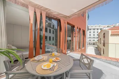 a table and chairs on a balcony with a view at Cine Park Residences by An Island Apart in Funchal