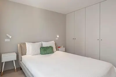 a white bedroom with a bed and a white cabinet at Cine Park Residences by An Island Apart in Funchal