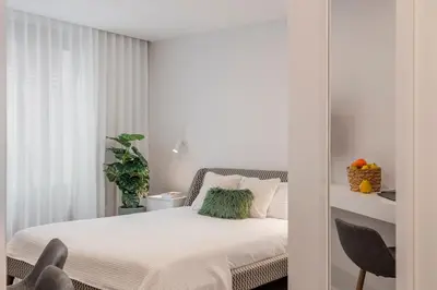 a white bedroom with a bed and a window at Cine Park Residences by An Island Apart in Funchal