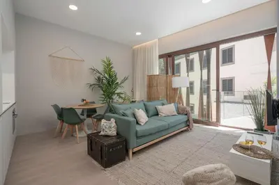 a living room with a green couch and a table at Cine Park Residences by An Island Apart in Funchal