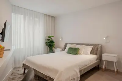 a white bedroom with a bed and a window at Cine Park Residences by An Island Apart in Funchal