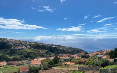 a kitchen with a dining table and a refrigerator at Country house in Arco da Calheta