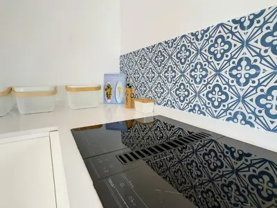 a kitchen with blue and white tiles on the wall at Villa Omar by LovelyStay in Canhas