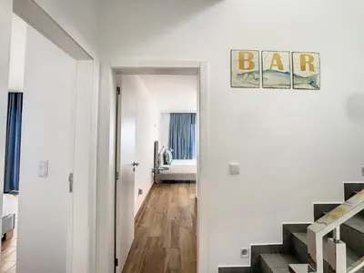 a white room with a hallway with a bar sign on the wall at Villa Omar by LovelyStay in Canhas