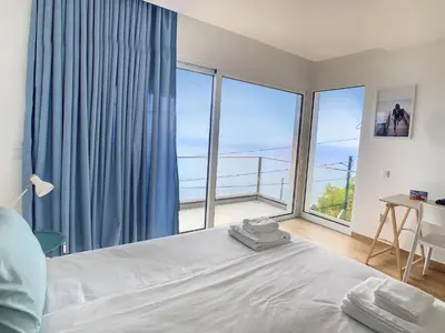 a bedroom with a bed and a large window at Villa Omar by LovelyStay in Canhas