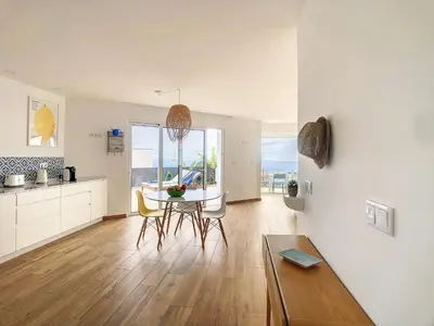 a kitchen and living room with a table and chairs at Villa Omar by LovelyStay in Canhas
