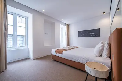 a bedroom with a bed and a large window at Casa do Batente - By WeHost in Funchal