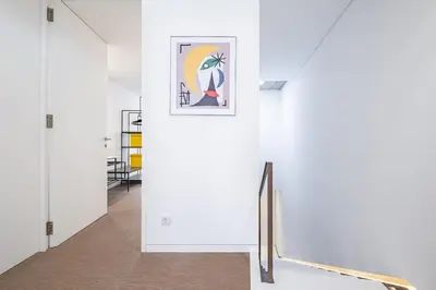 a hallway with white walls and a framed painting on the wall at Casa do Batente - By WeHost in Funchal