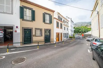 a street in a town with cars parked on the road at Casa do Batente - By WeHost in Funchal