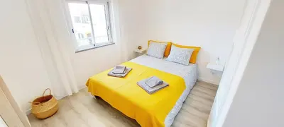 a small bedroom with a bed with a yellow blanket at Caroline's in Vila do Bispo