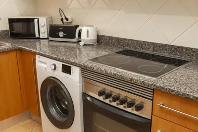 a kitchen with a stove and a washing machine at B73 - Luz Sun Holiday Apartment in Lagos
