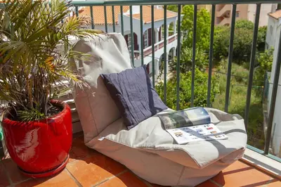 a chair sitting on a balcony with a potted plant at B73 - Luz Sun Holiday Apartment in Lagos
