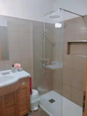 a bathroom with a shower and a toilet and a sink at Garajau Terrace Orchids in Caniço
