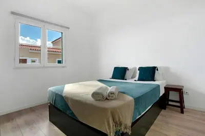 a white bedroom with a bed with a window at Jay Paradise in Santa Cruz