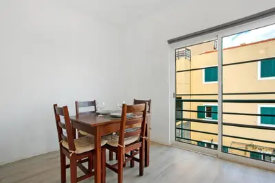 a dining room with a table and chairs and a large window at Jay Paradise in Santa Cruz