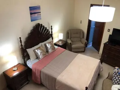 a bedroom with a large bed and a chair at Casa Bica do Cais - By the Sea in Paul do Mar