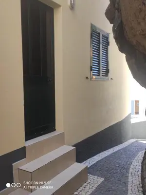 a building with a black door and some stairs at Casa Bica do Cais - By the Sea in Paul do Mar