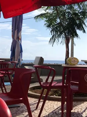 a group of chairs and tables with the ocean in the background at Casa Bica do Cais - By the Sea in Paul do Mar