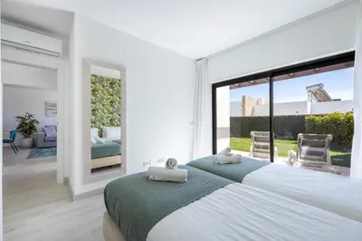 a bedroom with a large bed and a large window at Villa Drop in in Sagres