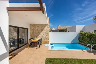 a patio with a table and a swimming pool at Villa Drop in in Sagres
