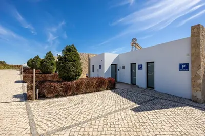 a white building on a brick road at Villa Drop in in Sagres