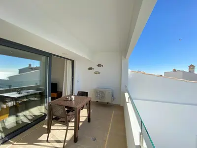 a room with a table and a balcony with a view at Estúdio com Fantástica Vista Mar - Praia da Luz in Luz