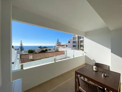 a balcony with a table and a view of the ocean at Estúdio com Fantástica Vista Mar - Praia da Luz in Luz
