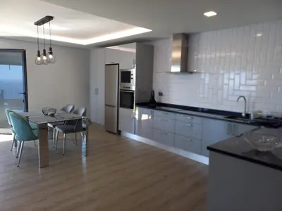 a kitchen and dining room with a table and chairs at Apartamento Domingos in Arco da Calheta
