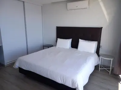 a bedroom with a large white bed with two pillows at Apartamento Domingos in Arco da Calheta