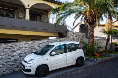 a white car parked in front of a building at Apartamento Domingos in Arco da Calheta