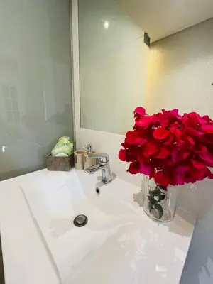 a bathroom sink with a vase of red roses at The Farm House.23 in Funchal