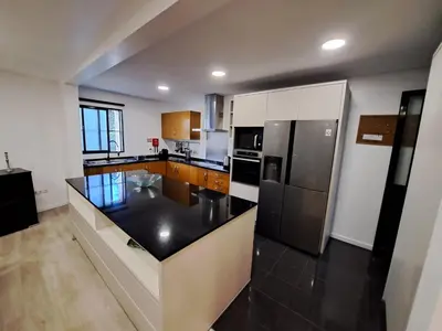 a kitchen with a black counter top and a refrigerator at Friendly house in Funchal