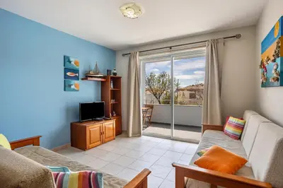 a living room with a couch and a tv at Sonho Dourado Apartamento de praia in Porto Santo