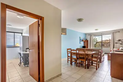 a dining room and kitchen with a table and chairs at Sonho Dourado Apartamento de praia in Porto Santo