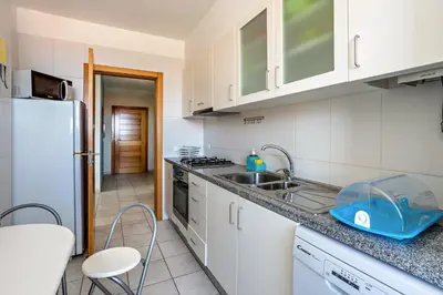 a kitchen with a sink and a refrigerator at Sonho Dourado Apartamento de praia in Porto Santo