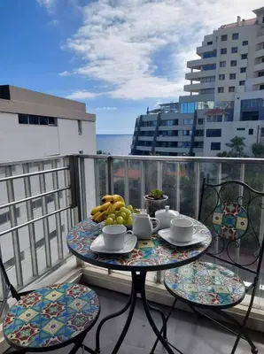 a table with a bowl of fruit on a balcony at A Cornes Of The Atlantic in Funchal