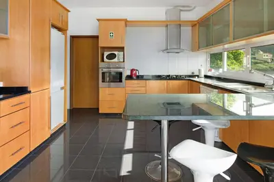a kitchen with wooden cabinets and a counter top at Madeira Villa Liliana in Campanário