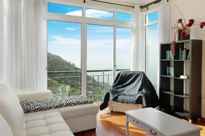 a living room with a white couch and a large window at Madeira Villa Liliana in Campanário