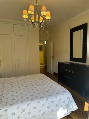a bedroom with a bed with a dresser and a chandelier at Luxury Sea View Apartment in Funchal