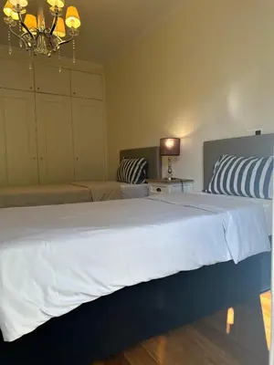 a bedroom with a large white bed and a chandelier at Luxury Sea View Apartment in Funchal