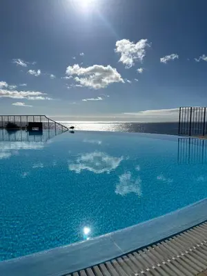 a large swimming pool with a view of the ocean at Luxury Sea View Apartment in Funchal