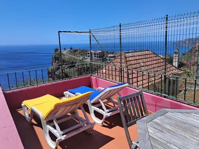 two chairs on a balcony with a view of the ocean at Westerland House in Ribeira Brava