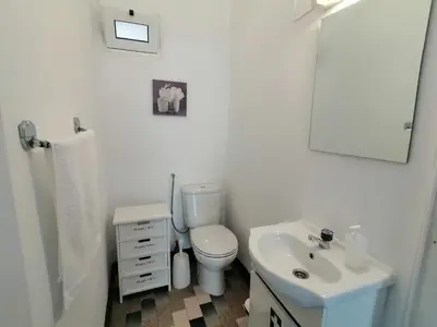 a bathroom with a white toilet and a sink at Westerland House in Ribeira Brava