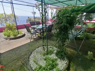 a bench in a garden with a welcome sign at Westerland House in Ribeira Brava